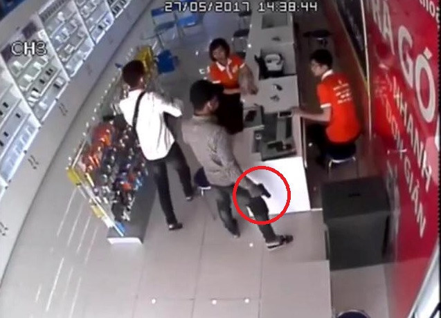 Hình ảnh từ camera cho thấy nam thanh niên cầm vật hình súng xông vào cửa hàng điện thoại. Ảnh cắt từ clip