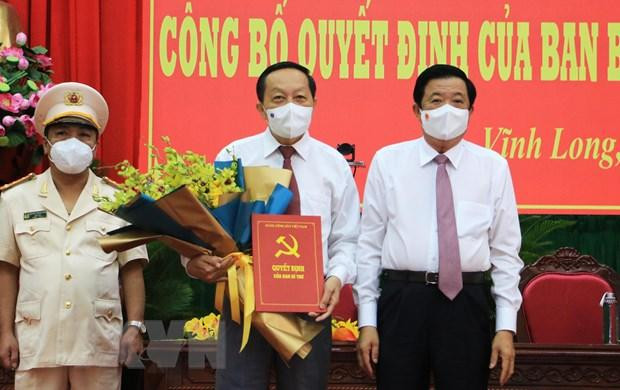 Bí thư Tỉnh ủy Vĩnh Long Bùi Văn Nghiêm trao Quyết định và tặng hoa chúc mừng ông Nguyễn Thành Thế. (Ảnh: Phạm Minh Tuấn/TTXVN)