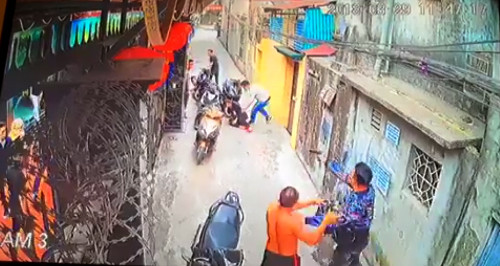 Nam thanh niên áo hoa nổ súng khiến một phụ nữ bị trọng thương vùng đùi. Ảnh cắt từ clip