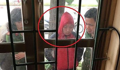 Bà Huyền (áo đỏ) bị cơ quan công an bắt quả tang đang nhận tiền của gia đình bị can.