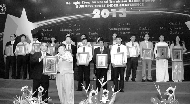 Bác sĩ Trần Thế Lộc (bên trái) - Giám đốc Điều hành, đại diện Manulife Việt Nam nhận biểu tượng “Doanh nghiệp phát triển bền vững năm 2013. ẢNH: Hòa Hội