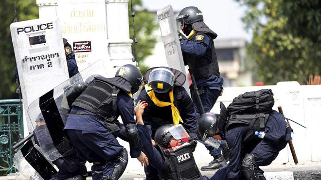 Cảnh sát cứu đồng đội bị thương trong vụ đụng độ. Ảnh: AP