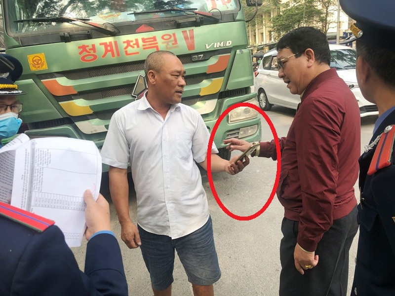 Thay vì chấp hành kiểm tra, tài xế xe tải 29C-573.27 vi phạm đẫ lấy điện thoại ra gọi và đưa cho TTGT nói chuyện (vòng tròn), nhưng TTGT đã từ chối.
