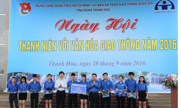 Anh Nguyễn Mạnh Dũng - Bí thư Trung ương Đoàn- cùng các đại biểu trao tặng dụng cụ hỗ trợ điểm cổng trường an toàn giao thông. Ảnh: Hoàng Lam.