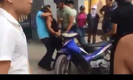 Người vi phạm bị người mặc thường phục (áo xanh) ghì cổ bẻ tay khống chế (ảnh cắt từ clip).