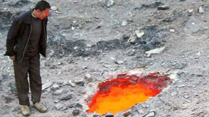 Một người dân đứng bên cạnh chiếc hố rực lửa ở ngoại ô Urumuqi, Tân Cương, Trung Quốc. Ảnh: Mirror.