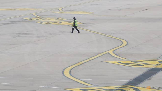 Một nhân viên đi trên đường băng của sân bay quốc tế ở Bắc Kinh ngày 9/3. (Ảnh: Reuters)