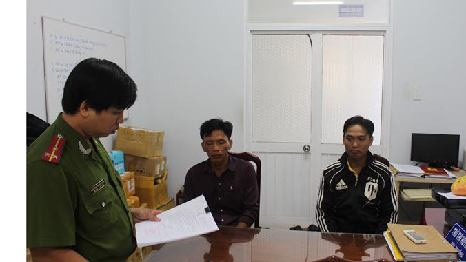 Công an đọc lệnh khởi tố hai đối tượng sản xuất trà giả.