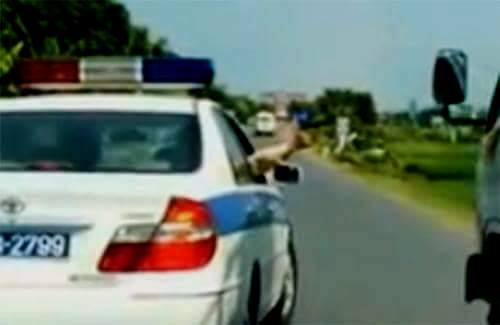 Cảnh sát rút súng bắn 3 phát súng thị uy. Ảnh cắt từ clip.