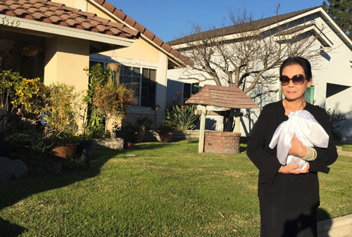 Khánh Ly ôm lọ tro cốt của chồng trở về nhà sau tang lễ.