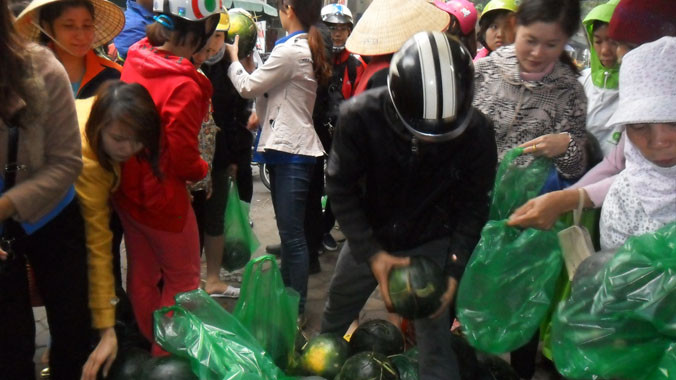 Thanh niên giúp đồng bào vùng ngập lụt bán dưa hấu