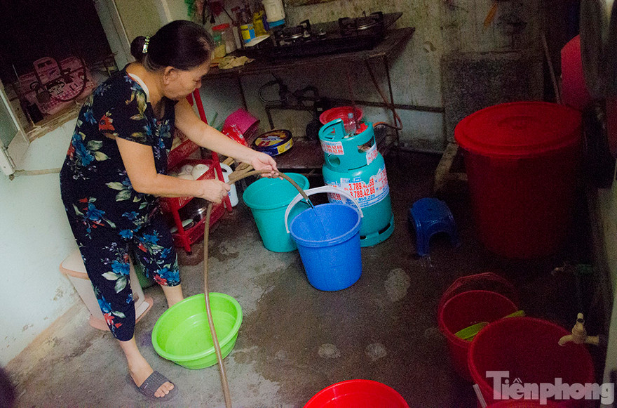 Bà Bạch Thị Quế đang bơm nước và xô đem về nhà để sinh hoạt. Ảnh: Thanh Hà.