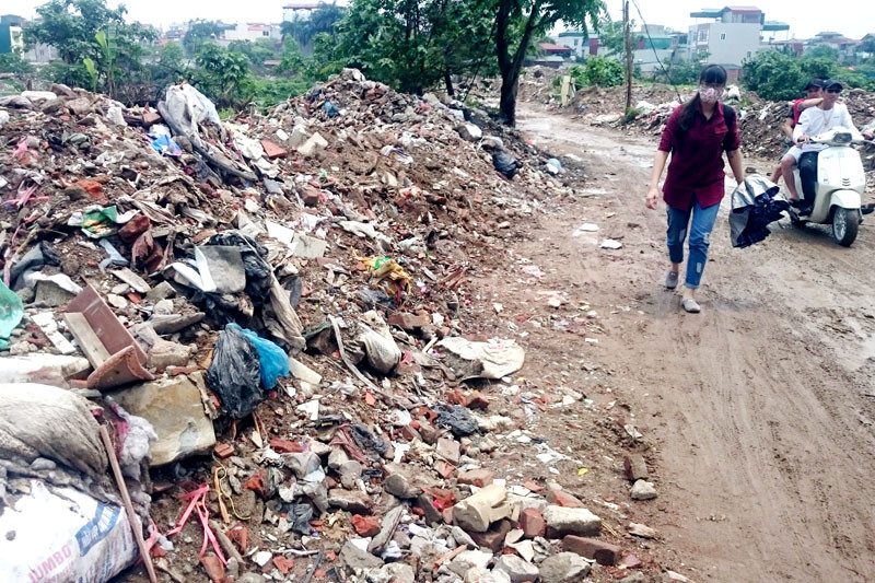 Ven lối đi dọc theo Đầm Hồng ngập tràn rác và phế thải xây dựng.
