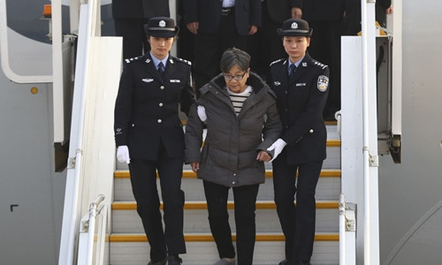 Dương Tú Châu bị áp giải xuống máy bay khi hạ cánh tại Bắc Kinh. Ảnh: Reuters