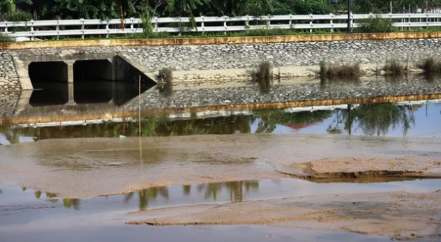 Bùn thải do Nhà máy nước Hưng Vĩnh xả ra lấp đầy một góc hồ điều hòa. Ảnh: Dân sinh