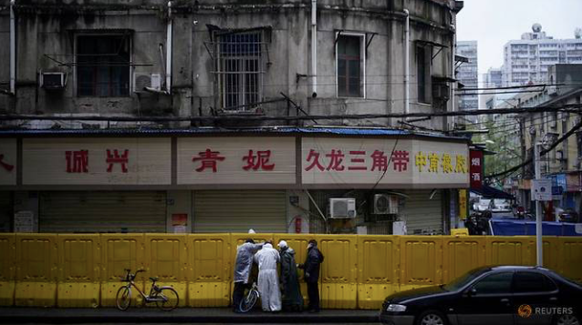 Các công nhân sửa lại rào chắn ở Vũ Hán, tỉnh Hồ Bắc. (Ảnh: Reuters)