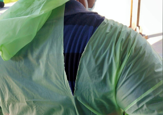 Một bác sĩ Ấn Độ mặc áo mưa rách khi làm việc tại bệnh viện chữa trị cho bệnh nhân COVID-19. (Ảnh: Reuters)