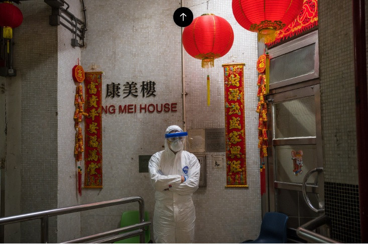 Một cán bộ mặc đồ bảo hộ đứng ngoài tòa nhà đang nghi nCoV lây qua hệ thống đường ống. (Ảnh: Getty Images)