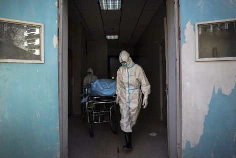 Nhân viên y tế di chuyển một bệnh nhân Covid-19 tại bệnh viện ở Vũ Hán. (Ảnh: AP)