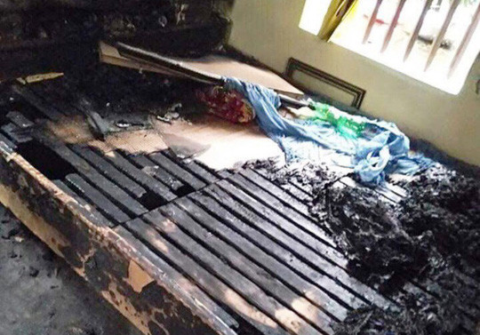 Chiếc giường nơi vợ chồng ông L đang ngủ bị đổ xăng đốt 