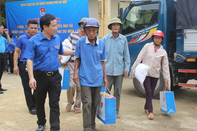 Anh Trần Anh Tuấn (Phó bí thư thường trực Thành Đoàn Hà Nội) trao quà cho người dân xã Phúc Đồng (huyện Hương Khê, Hà Tĩnh).