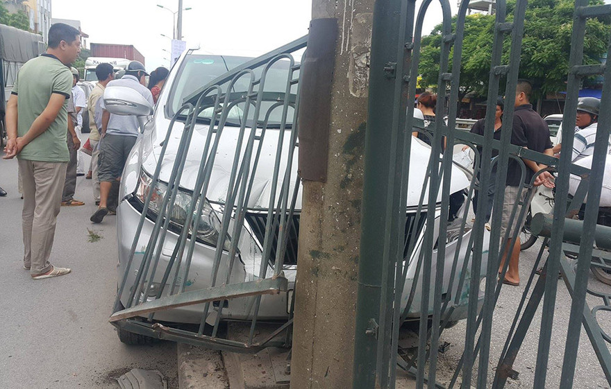 Chiếc xe Lexus đâm tung hàng rào sắt mắc kẹt trên dải phân cách.