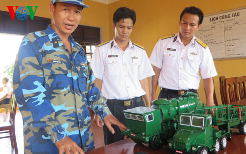 Trung úy chuyên nghiệp Hoàng Văn Tuấn, đội Hỏa lực, Lữ đoàn 679 đang giới thiệu về mô hình xe nạp đạn, xe bệ phóng tên lửa 