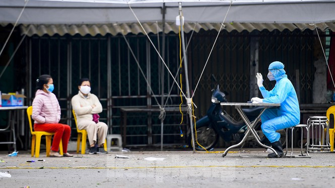  Người dân Hạ Lôi ngồi chờ xét nghiệm y tế. Ảnh: Hoàng Mạnh Thắng