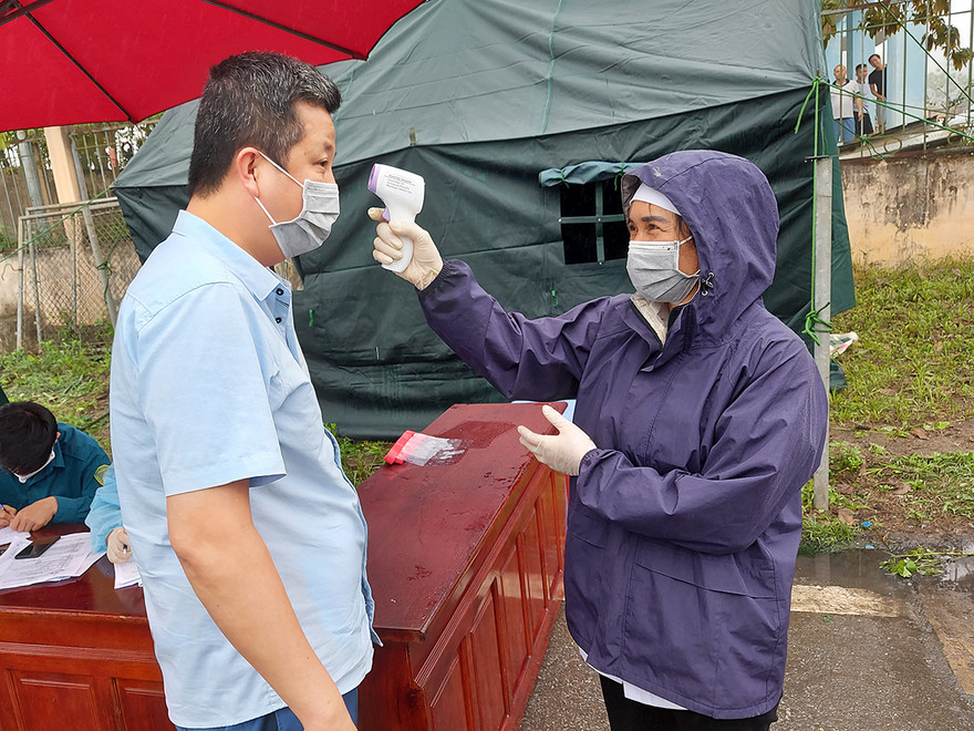 Nhân viên Y tế tỉnh Yên Bái kiểm tra thân nhiệt của khách ra vào tỉnh này. Ảnh: Tuấn Nguyễn