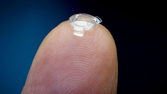 Bác sĩ Garth Webb đặt thấu kính sinh học trên ngón tay. Ảnh: Canadian Press.