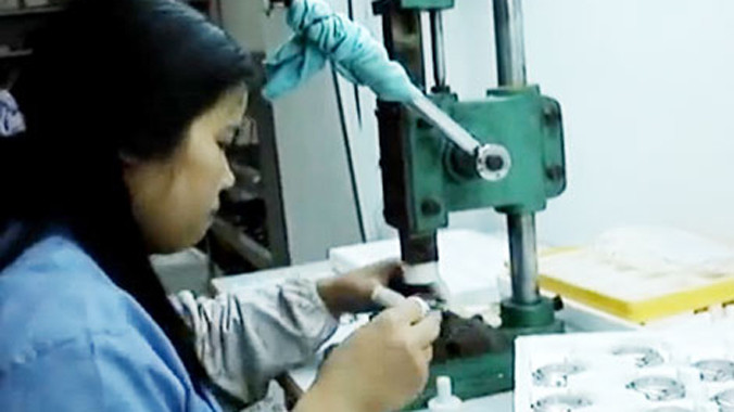 Ép mặt kính đồng hồ giả bằng máy thủ công.