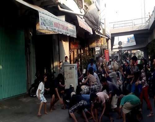 Dùng vợt tự chế để tranh cướp đồ cúng cô hồn. Ảnh: Khánh Ly.