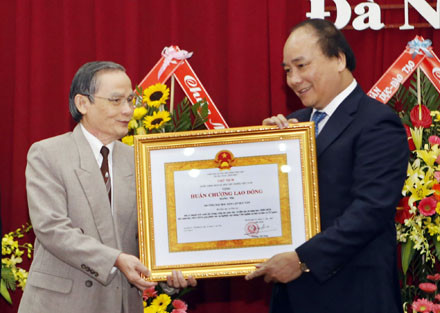 Chủ tịch kiêm hiệu trưởng ĐH Duy Tân, nhà giáo ưu tú Lê Công Cơ đón nhận Huân chương Lao động hạng Nhì từ Phó Thủ tướng Nguyễn Xuân Phúc. Ảnh: Lê Lâm