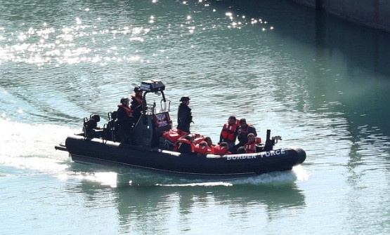 Lực lượng tuần tra Anh vừa cứu được một nhóm người di cư bất hợp pháp bơi trên biển. (Ảnh: EPA)