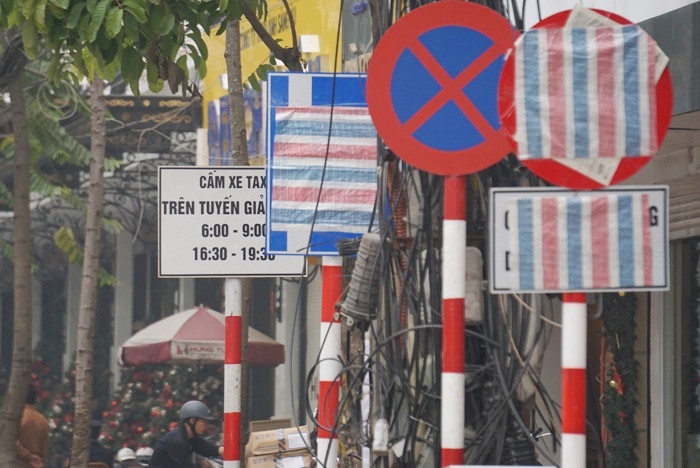 Biển báo giao thông bị bịt kín trên một số tuyến phố Hà Nội.