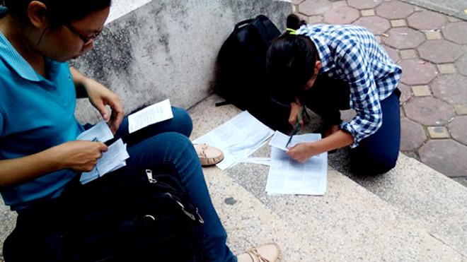 Thí sinh in sao tài liệu rồi cắt, dán, đóng gim bên ngoài cửa hàng photo. Ảnh: Minh Minh