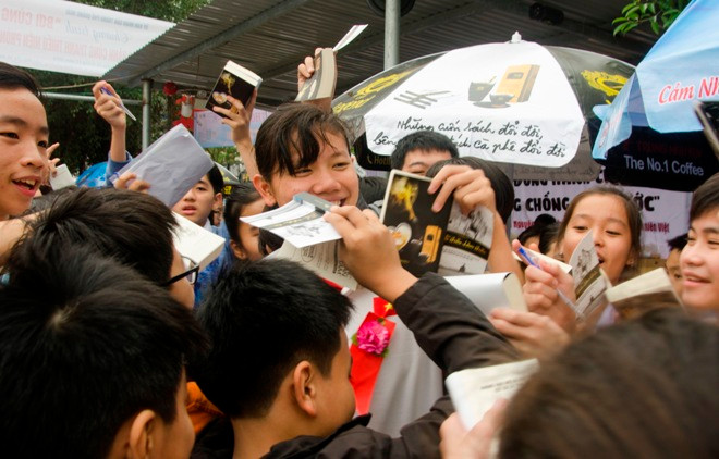 Kình ngư Ánh Viên đang khiêng quà tặng ra xe cho bà Trịnh Thị Hơn, người bị thiệt hại trong đợt lũ