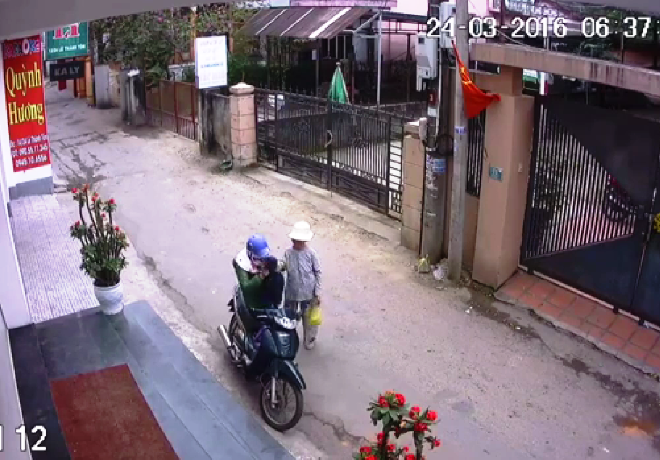 Người phụ nữ dừng bắt chuyện và thản nhiên lấy chiếc áo khác đen của bà lão bỏ vào giỏ trước của xe máy.