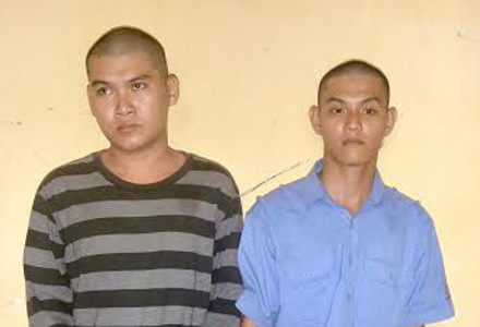  Nguyễn Thanh Phương (áo xanh) và Nguyễn Thế Thanh (áo sọc) tại cơ quan công an. 