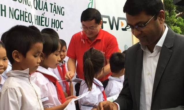 Ông Anantha và ông Lê Xuân Sơn trao học bổng cho học sinh.