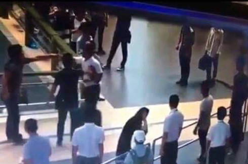 Người đàn ông (áo đen ngoài cùng bênn trái) đã giải cứu nữ nhân viên hàng không. Ảnh cắt từ clip. 