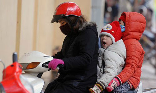 Học sinh ngái ngủ trên đường đến trường, ngày rét. 