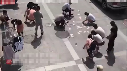 Người dân tranh nhau nhặt tiền trên trời rơi xuống.