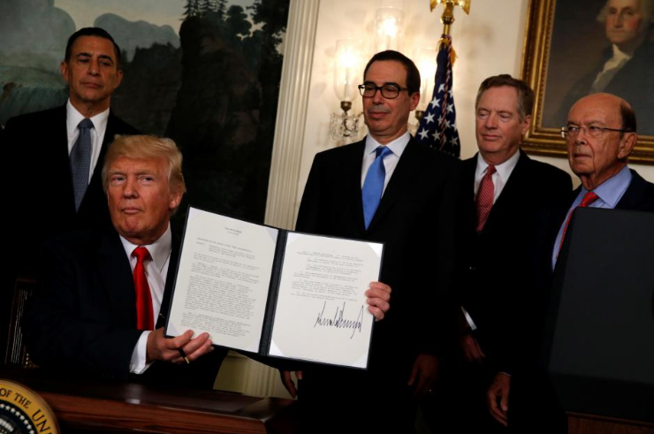 Tổng thống Mỹ Donald Trump ký văn bản ủy quyền cho Đại diện Thương mại Mỹ Robert Lighthizer để xem xét mở cuộc điều tra thương mại đối với Trung Quốc hôm 14/8. Ảnh: Reuters