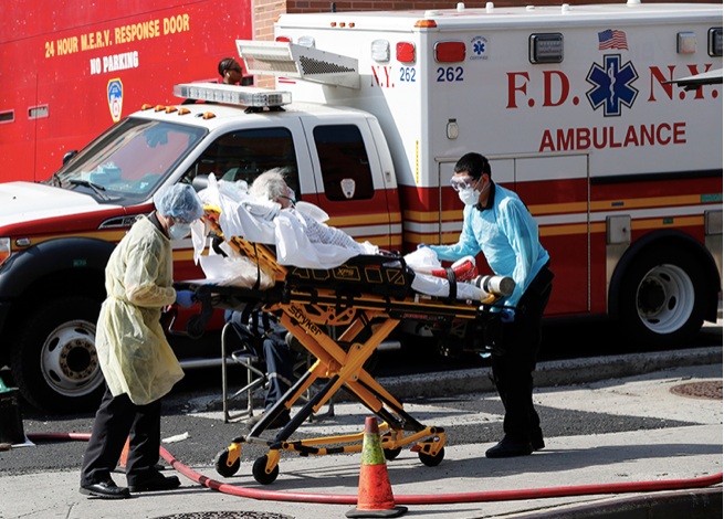  Một bệnh nhân được vận chuyển từ Trung tâm bệnh viện Elmhurst, Mỹ, ra xe cứu thương ngày 7/4. (Ảnh: AP) 