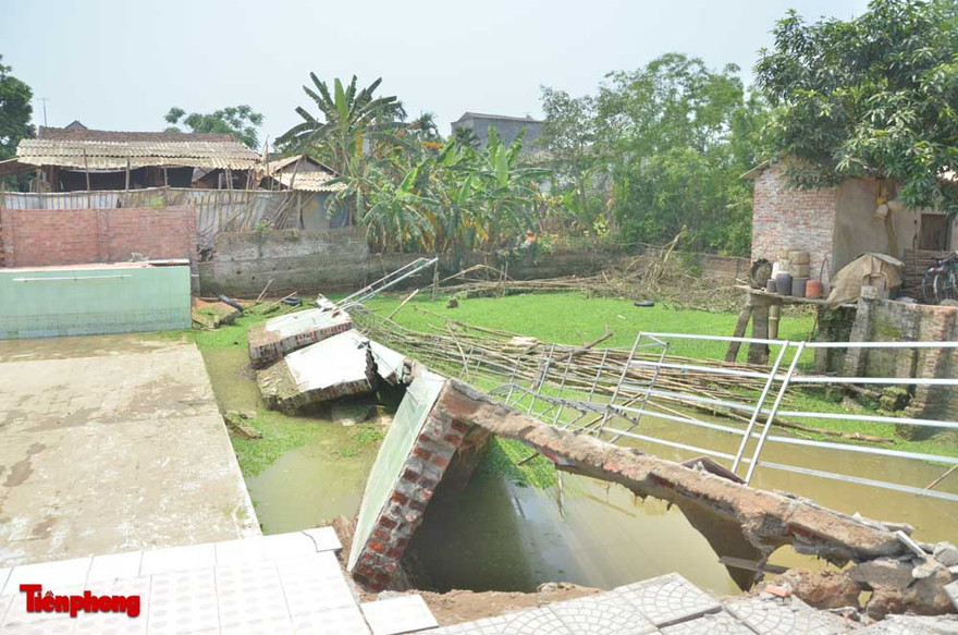 Bức tường lớn của bể vỡ xuống ao. Ảnh: Thanh Hà.