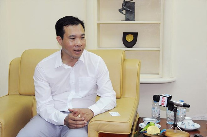 Xạ thủ Hoàng Xuân Vinh trả lời phỏng vấn cơ quan ngôn luận lớn nhất Trung Quốc.Ảnh: Tân Hoa Xã.