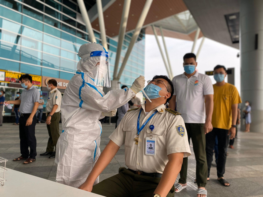 Lấy mẫu xét nghiệm SARS-CoV-2 ở sân bay Đà Nẵng. Ảnh: NLĐ