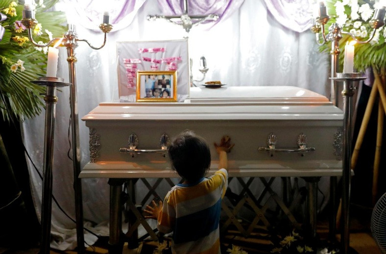 Anh trai cô bé Myka Ulpina đứng trước thi thể em gái. (Ảnh: Reuters)