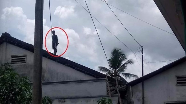 Thanh niên cố thủ trên nóc nhà từ 4 giờ sáng